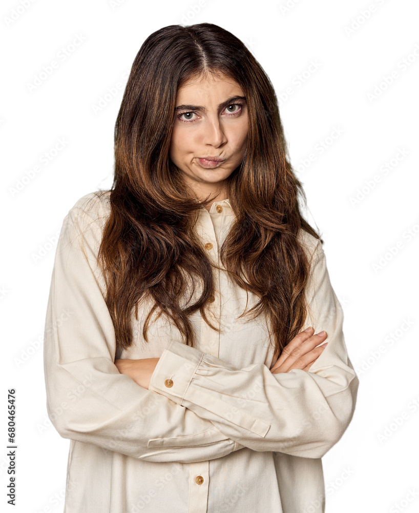 Young Caucasian woman in studio setting frowning face in displeasure, keeps arms folded. Young Caucasian woman in studio setting frowning face in displeasure, keeps arms folded.