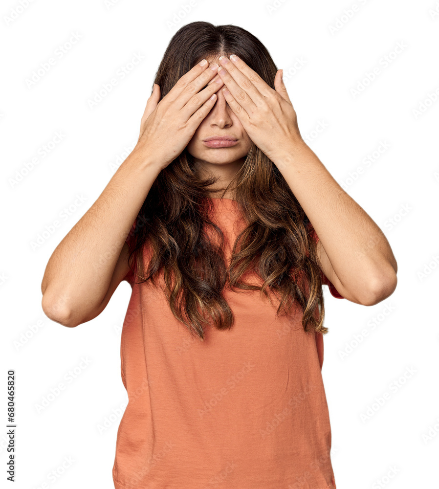 Young Caucasian woman in studio setting afraid covering eyes with hands. Young Caucasian woman in studio setting afraid covering eyes with hands.