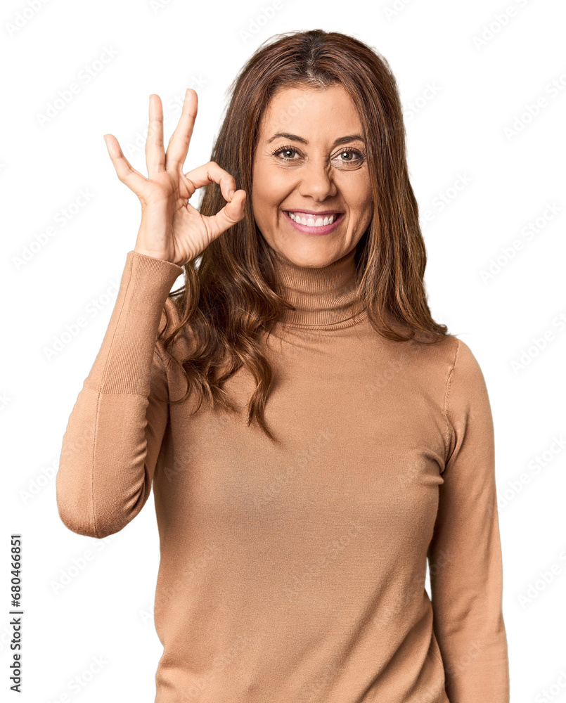 Middle-aged woman portrait in studio setting cheerful and confident showing ok gesture. Middle-aged woman portrait in studio setting cheerful and confident showing ok gesture.