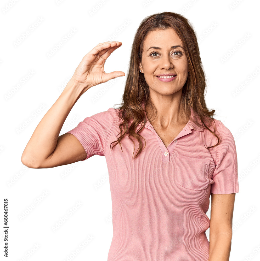 Middle-aged woman portrait in studio setting holding something little with forefingers, smiling and confident. Middle-aged woman portrait in studio setting holding something little with forefingers, smiling and confident.