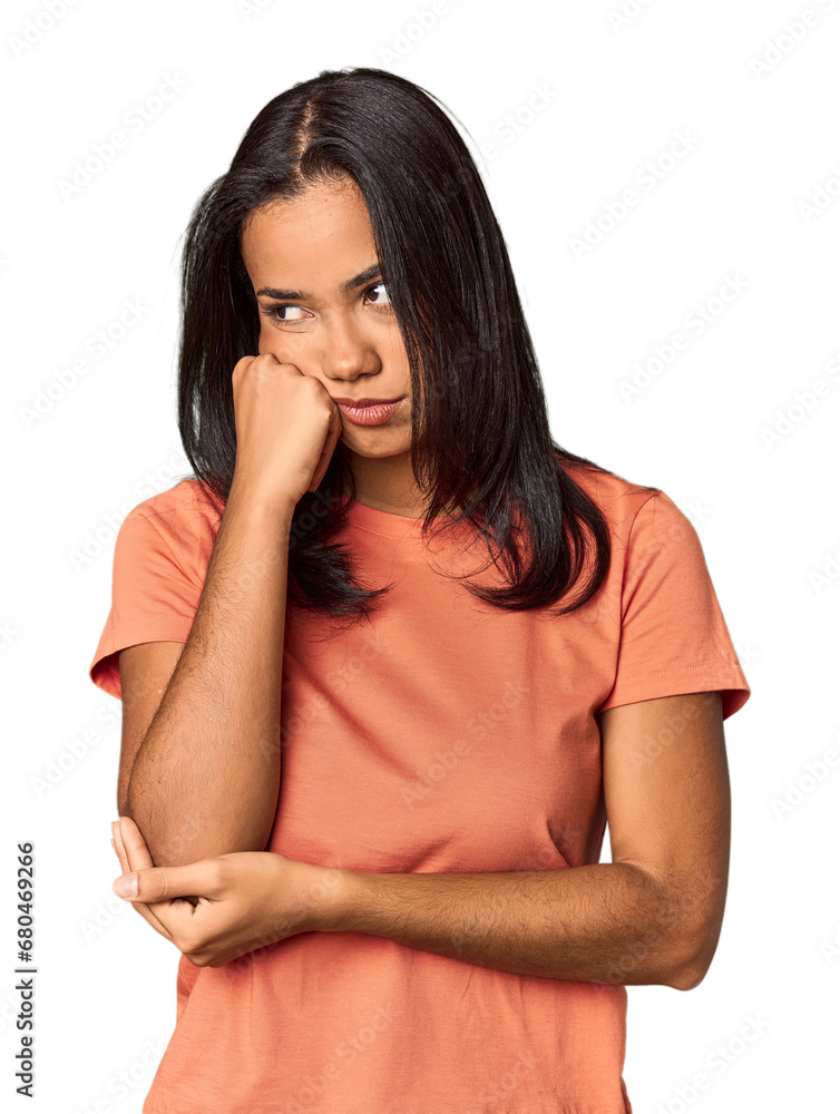 Young Filipina with long black hair in studio who feels sad and pensive, looking at copy space. Young Filipina with long black hair in studio who feels sad and pensive, looking at copy space.