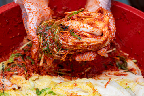 소금에 절인 배추에 각종 양념을 추가해 배추김치를 만드는 여성의 손 클로즈업