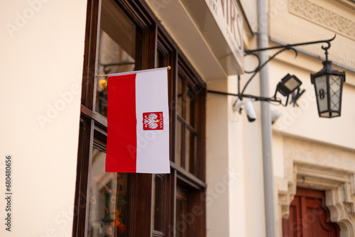 Flag of Poland on facade of a building waving in the wind. Celebrating Polish National Flag Day. Poland national flag with emblem