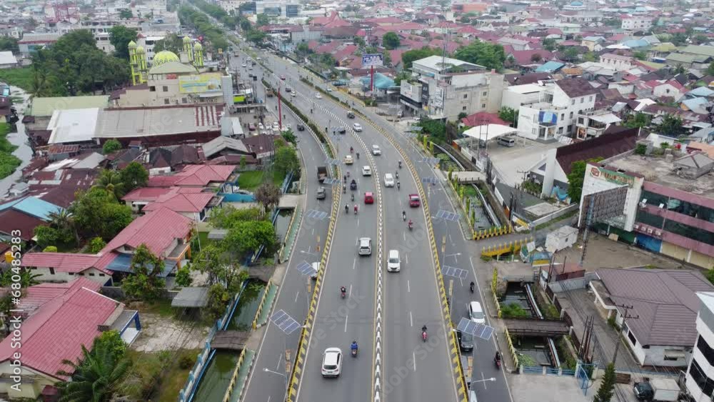 The long flyover in Banjarmasin is passed by many cars and motorbikes The long flyover in Banjarmasin is passed by many cars and motorbikes