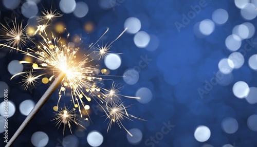 Sparkler burning bright with shiny sparks. Dark blue festive background. Happy New Year concept.