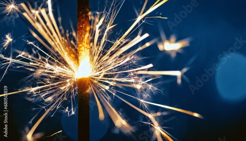 Sparkler burning bright with shiny sparks. Dark blue festive background. Happy New Year concept.