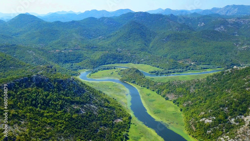 Aerial view over Rijeka Crnojevica from the Pavlova Strana viewpoint, Lake Skadar, Montenegro, Clean river and huge mountains, Water is covered by waterlily. Great location for holiday.