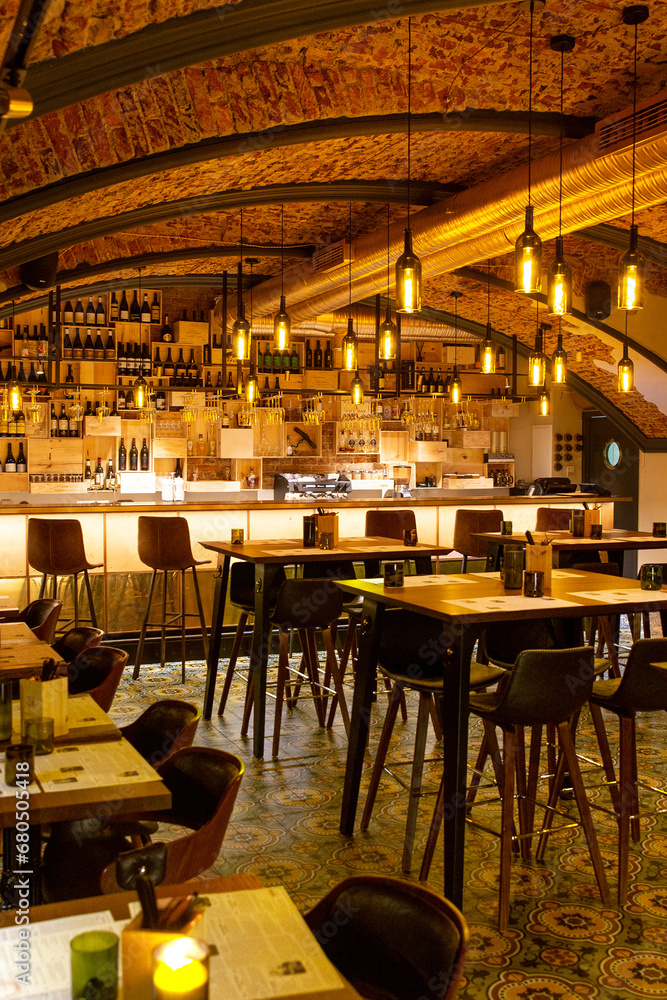 Interior of cozy modern restaurant with a bar counter and lamp lighting
