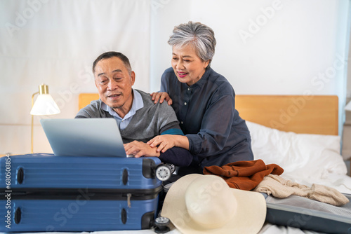 Senior elderly asian couple use laptop for hotel and resort booking online summer holiday travel planning searching information weekend vacation trip.reservation online, senior retirement concept © Art_Photo