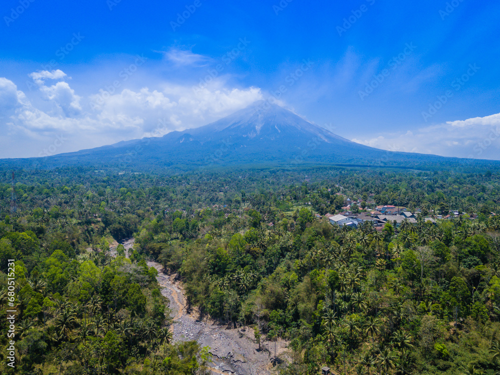 AerAerial view of Semeru mountain, blue cloudy sky and jungle near Tumpak Sewu Waterfall in Java in East Java, Indonesia