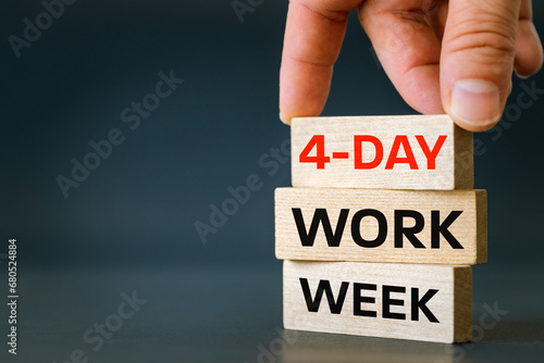 4-day work week symbol, conceptual words "4-day work week" arranged by hand on wooden blocks, beautiful navy blue background. Business concept and 4-day work week. Copy space