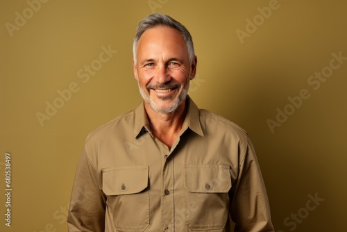 Portrait of a blissful man in his 50s sporting a breathable hiking shirt against a soft brown background. AI Generation photo