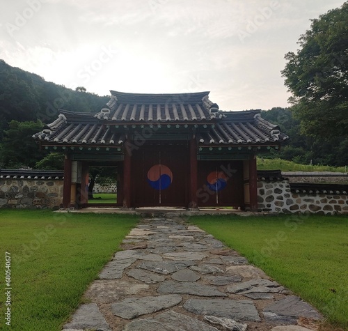 Korean-style traditional temple gate with Taegeuk pattern, majestic and eerie atmosphere in the mountains