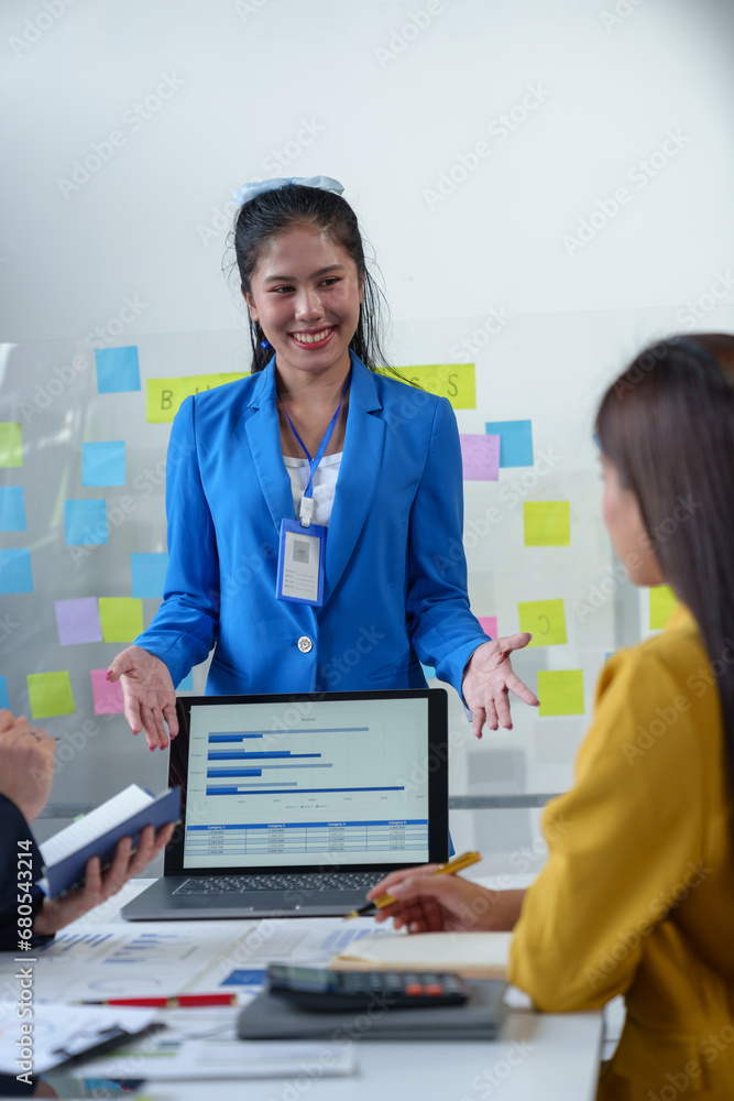 Group of colleagues, Asian businesswomen presenting and explaining investment project reports and planning strategies Budget calculation, business growth report on company laptop. Group of colleagues, Asian businesswomen presenting and explaining investment project reports and planning strategies Budget calculation, business growth report on company laptop.
