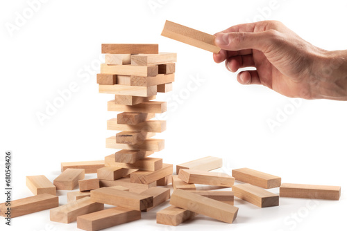 Obraz na plátně The tower from wooden blocks and man's hand take one block