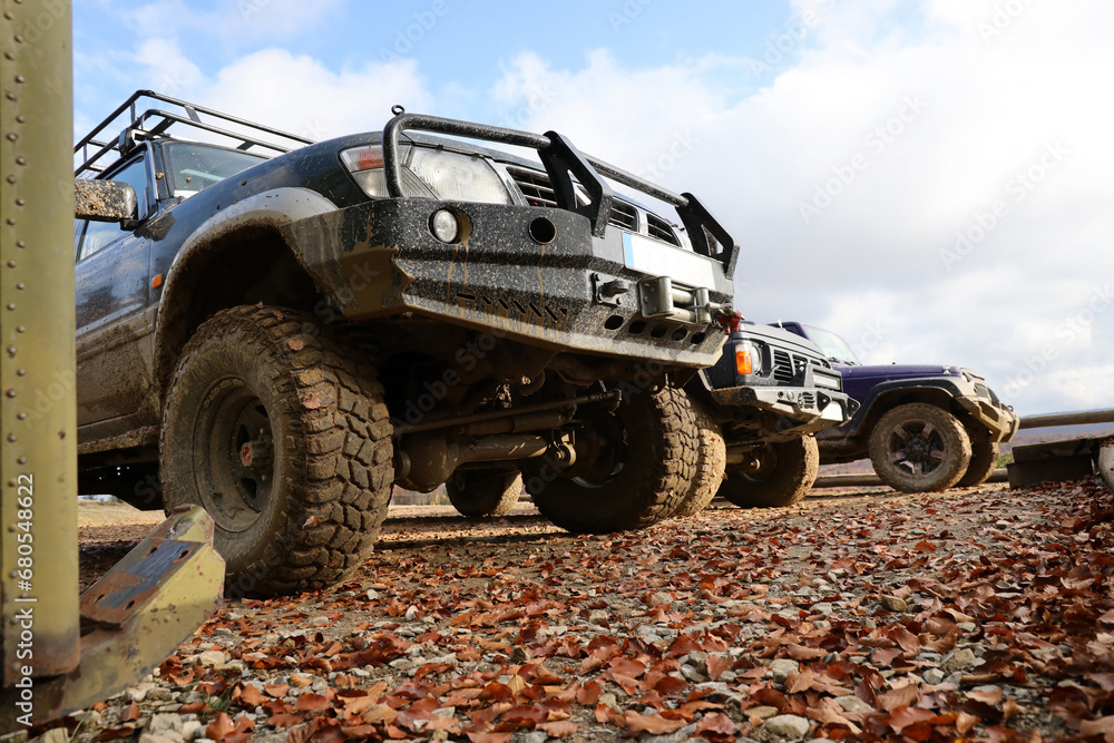 Automobile in a countryside landscape with a mud road. Off-road 4x4 suv automobile with ditry body after drive in muddy road area Automobile in a countryside landscape with a mud road. Off-road 4x4 suv automobile with ditry body after drive in muddy road area
