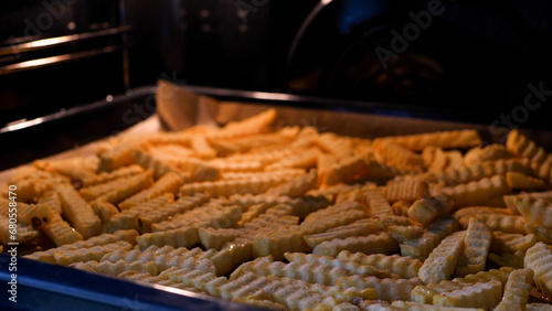 Frozen french fries baking inside an oven