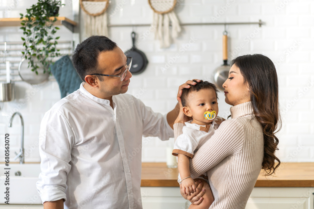 Obraz premium Portrait of enjoy happy love family asian father and mother playing with adorable little asian baby.dad touching with cute son moments good time in a white bedroom.Love of family concept