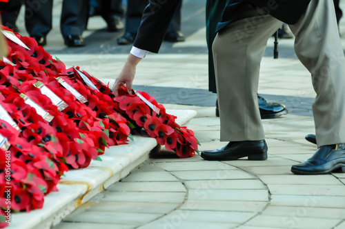 A man lays a poppy wreath on the steps of the Cenotaph during the remembrance ceremony photo