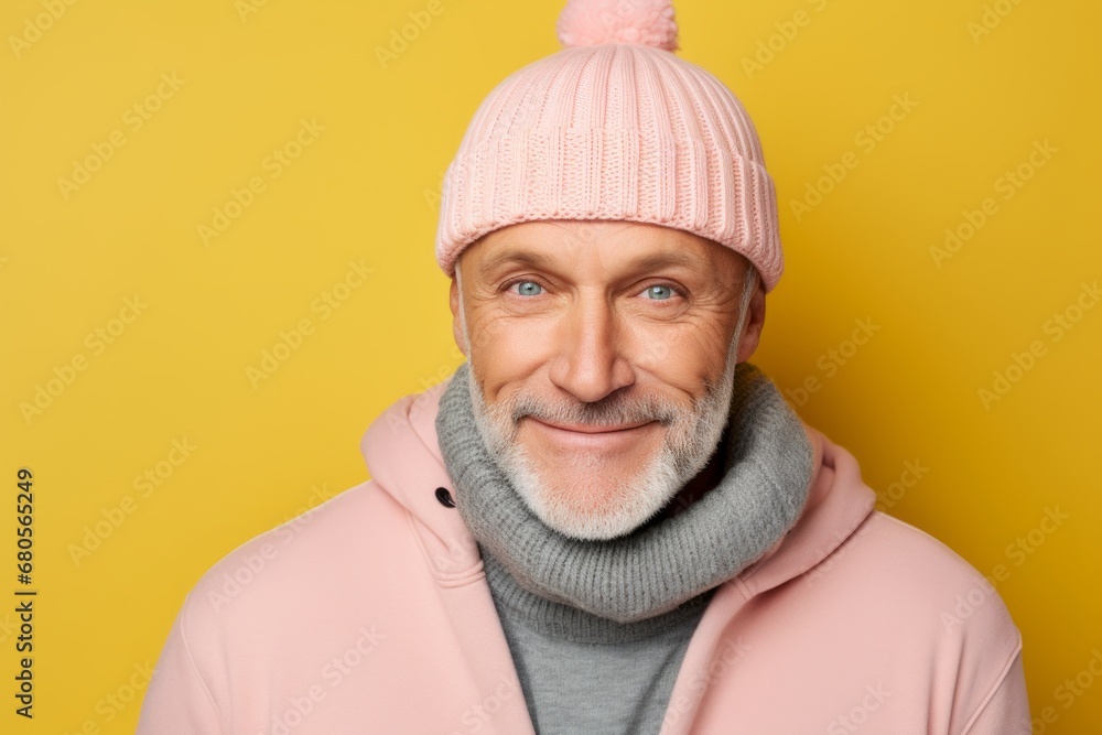Portrait of a cheerful man in his 50s dressed in a warm ski hat against a solid pastel color wall. AI Generation Portrait of a cheerful man in his 50s dressed in a warm ski hat against a solid pastel color wall. AI Generation