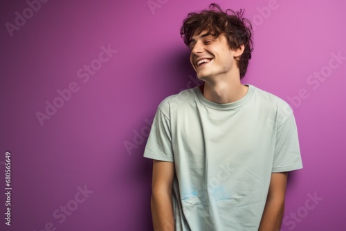 Portrait of a joyful man in his 20s sporting a vintage band t-shirt against a solid pastel color wall. AI Generation