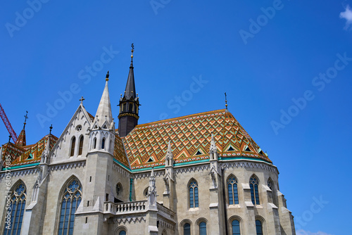 Close ups of the decorative roof with orange and green colors, windows and spires of the 13th-century church Matthias Church in Budapest, Hungary.