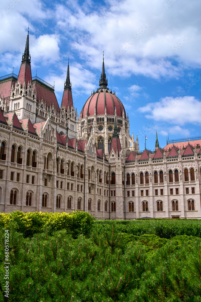 Hungarian Parliament Building on a summer day with green bushes in foreground in central Budapest, Hungary.