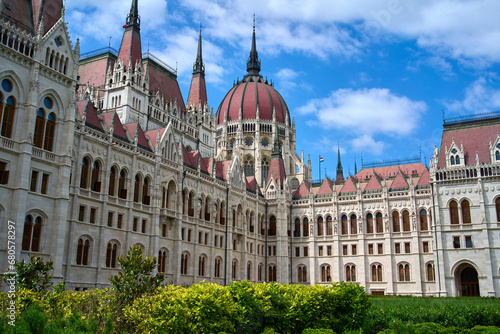 Hungarian Parliament Building on a summer day with green bushes in foreground in central Budapest, Hungary.