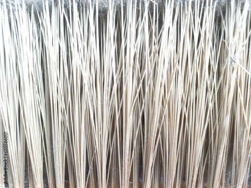Vertical stripes pattern and texture of brown broom plastic bristles. Close up. Concept photo for background, texture or pattern object.