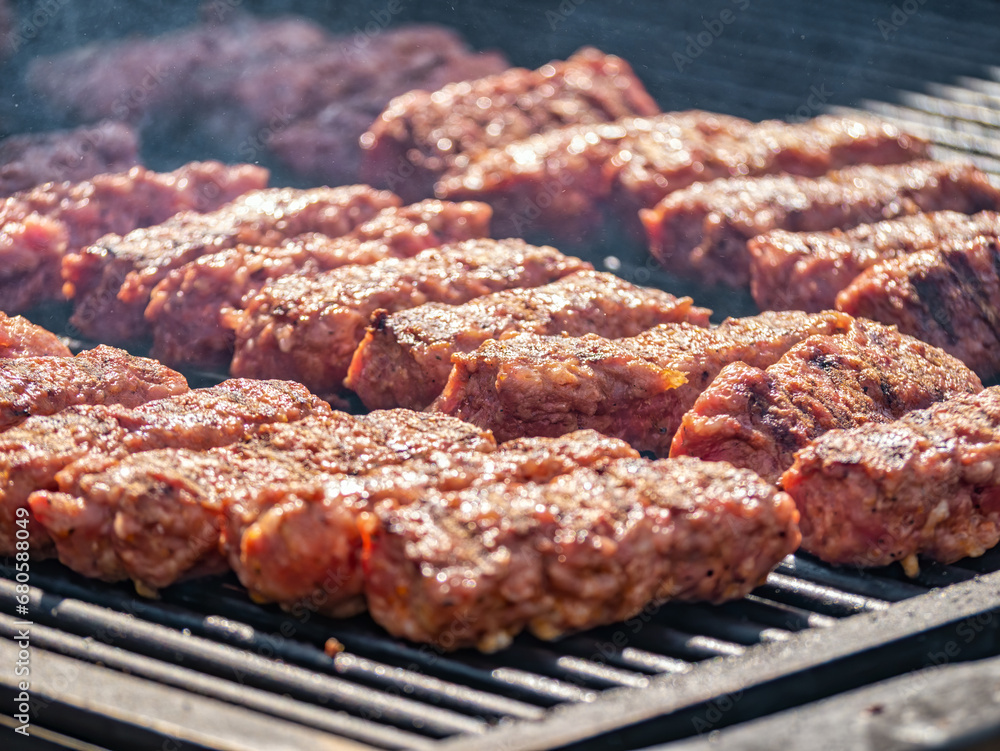 Mititei ( ground meat rolls) made from a mixture of beef,lamb with spices on the grill. Traditional romanian dish Mititei ( ground meat rolls) made from a mixture of beef,lamb with spices on the grill. Traditional romanian dish