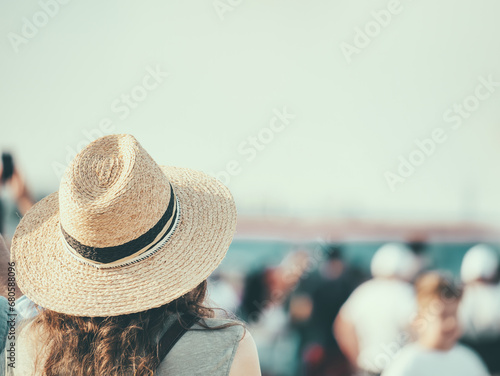 Back view picture of a woman wearing a elegant hat.