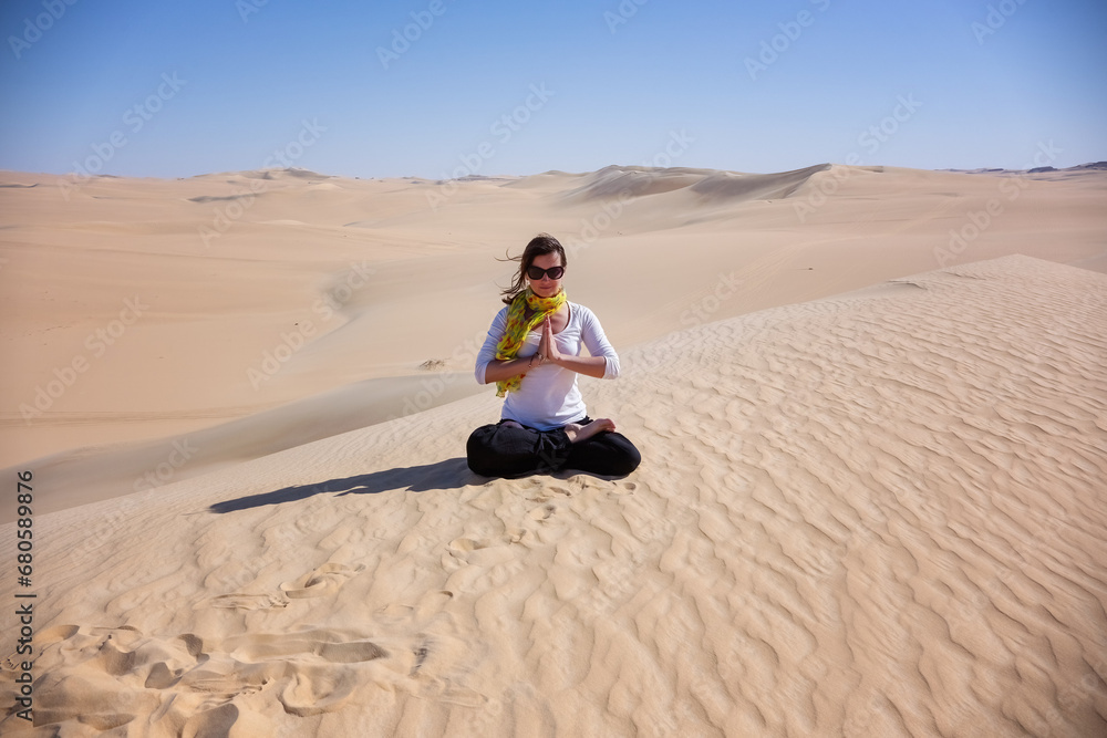 Woman sitting in lotus pose in the desert Egypt