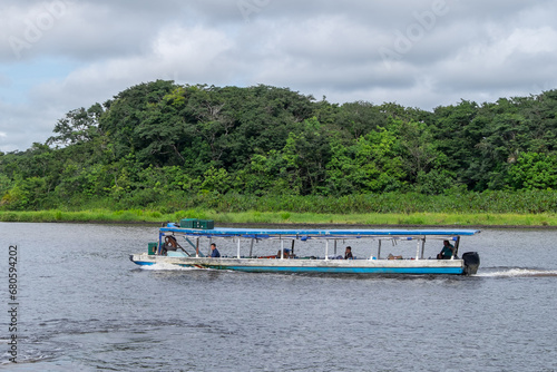 Barco de transporte fluvial navegando por el canal de Tortuguero en la provincia de Limón, Costa Rica photo