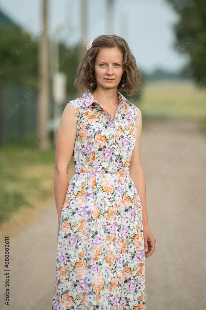 Beautiful young girl in a summer dress outdoors in the village. Beautiful young girl in a summer dress outdoors in the village.