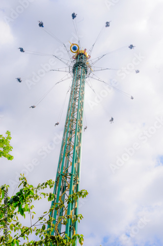 Very tall 'chairplanes' ride with people riding spinning swings which are swung out while very high up.