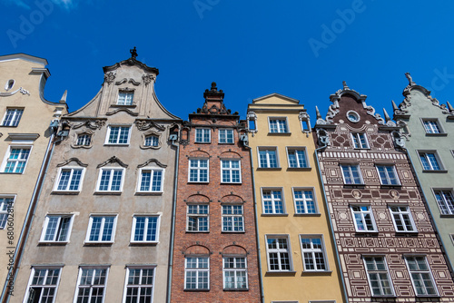 Facade of row of colorful historical houses in the Old Town of Gdansk, Poland, set against a clear blue summer sky