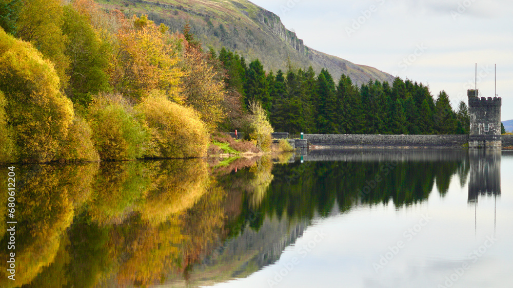 Autumn reflections at Llwyn-on,or Llwyn Onn Reservoir. The leaves have changed colour along the edge of the largest of three reservoirs in the Taf Fawr valley in the Brecon Beacons and South Wales. 