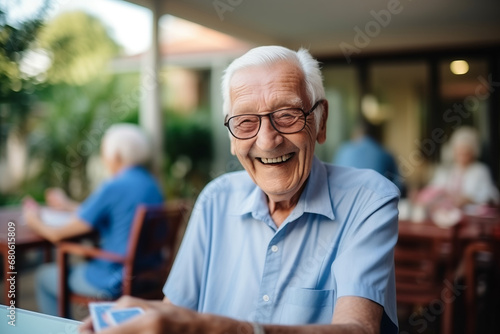 Happy senior man playing card games with friends, activity social networking in nurs home. Concept enjoying playtime together in poker game, old men