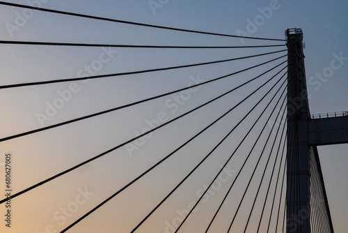 Cable stayed suspension bridge known as the Vidyasagar Setu built on the river Ganges at sunset with view of a boat seen from Princep Ghat at Kolkata, India photo
