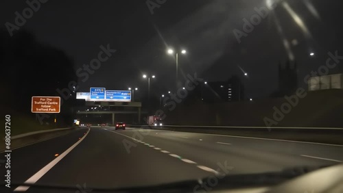 Blurry car dashboard and windshield view driving M602 highway at night in Salford, Greater Manchester, United Kingdom. photo