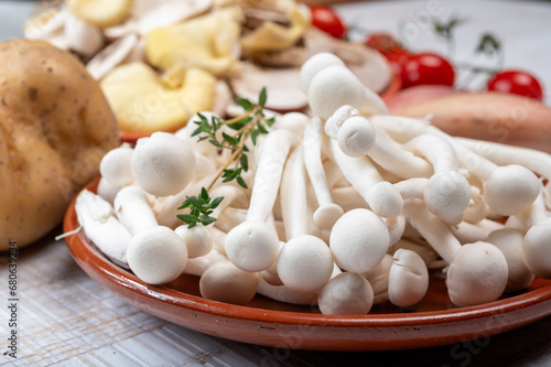 Ingredients for dinner dish with potato and mushrooms with onion. White shimeji edible mushrooms native to East Asia, buna-shimeji is widely cultivated