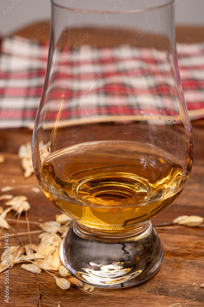 Tasting of different Scotch whiskies strong alcoholic drinks, drum of whiskey and colorful Scotch tartan on background close up Tasting of different Scotch whiskies strong alcoholic drinks, drum of whiskey and colorful Scotch tartan on background close up
