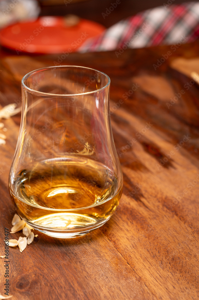 Tasting of different Scotch whiskies strong alcoholic drinks, drum of whiskey and colorful Scotch tartan on background close up Tasting of different Scotch whiskies strong alcoholic drinks, drum of whiskey and colorful Scotch tartan on background close up