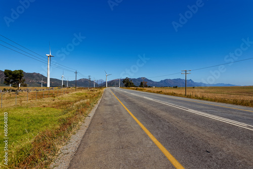 Fototapeta Naklejka Na Ścianę i Meble -  Wind turbines in an open field with blue skies near Porterville in the Western Cape, South Africa.