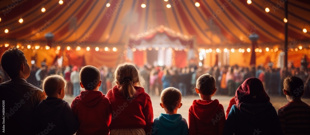 rear view kid children watching show on stage in circus carnival festive celebration in dome tent with crowd people inside exited lifestyle - obrazy, fototapety, plakaty 