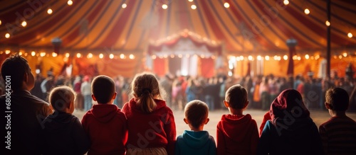 rear view kid children watching show on stage in circus carnival festive celebration in dome tent with crowd people inside exited lifestyle photo