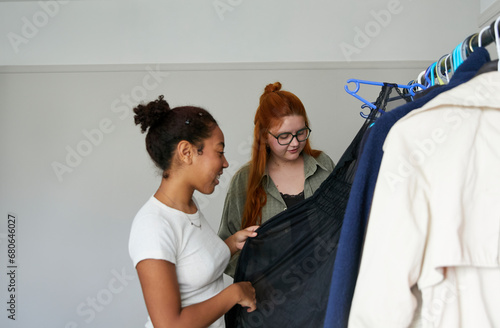 Gen Z girl showing off her thrifted clothing on her clothing rack. Concept of gender-neutral and sustainable fashion and self expression