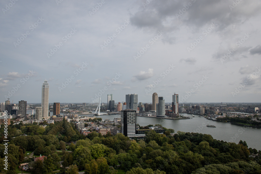 Fototapeta premium Cosmopolitan famous Dutch city Rotterdam with skyscraper buildings and river Nieuwe Maas. Aerial daytime view of skyline in Holland