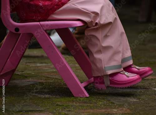 A child in pink clothes sitting on a pink chair