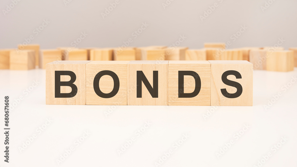text BONDS made of wooden cubes and different wooden blocks on grey background text BONDS made of wooden cubes and different wooden blocks on grey background